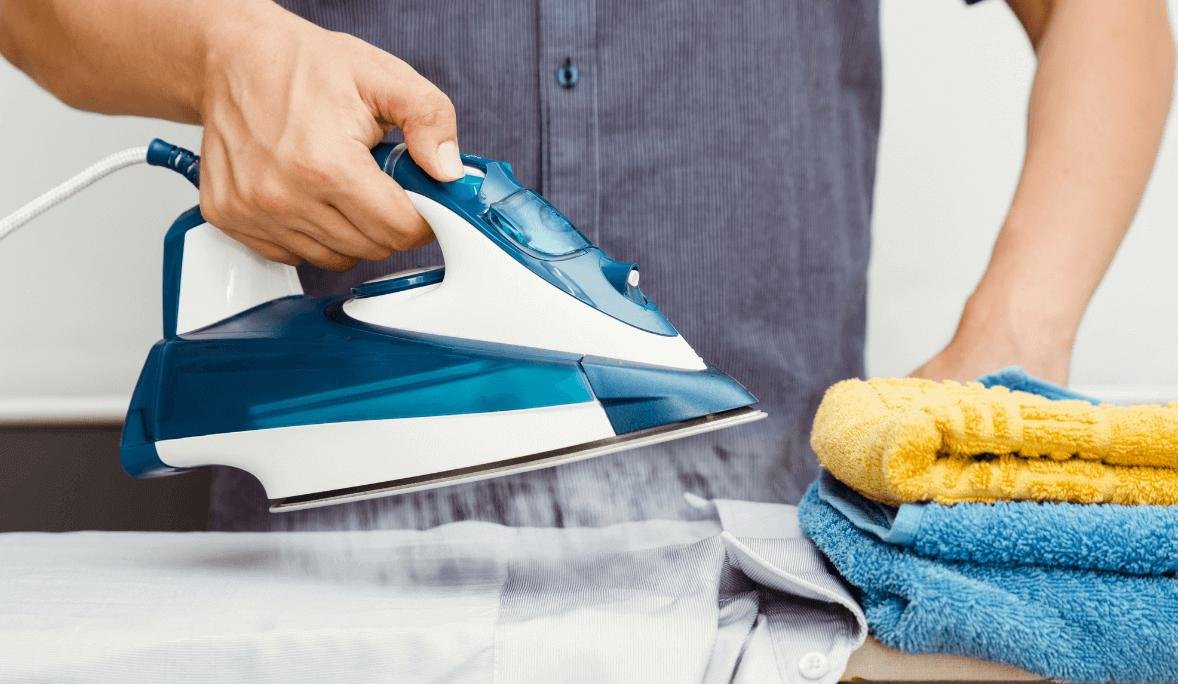 steaming a shirt with blue iron near towels.